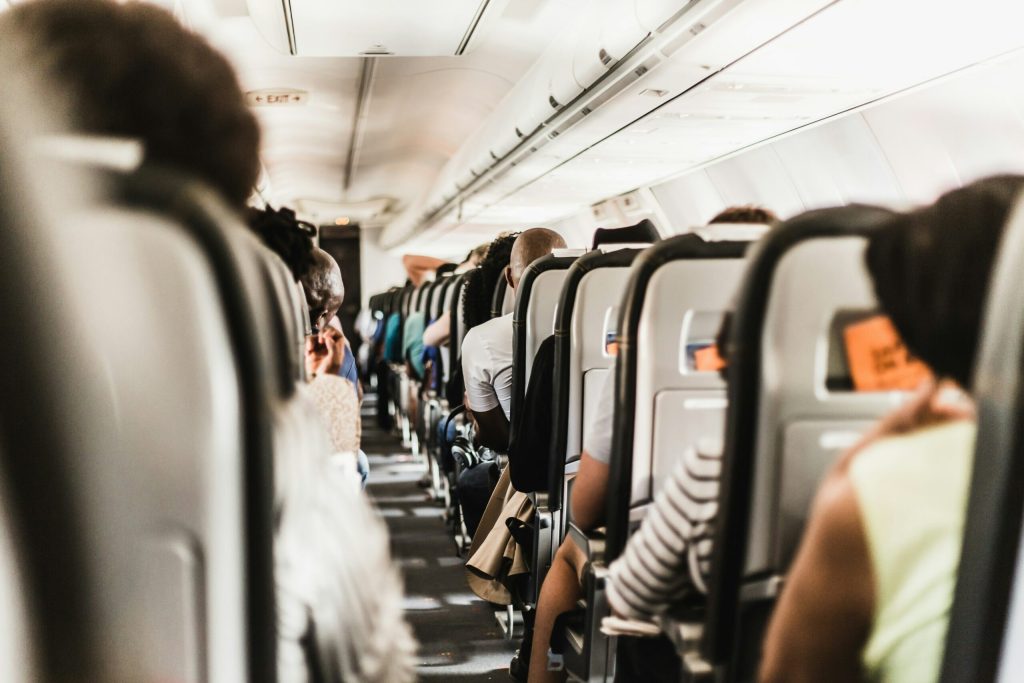 Looking down an airplane aisle at rows of seats occupied by passengers